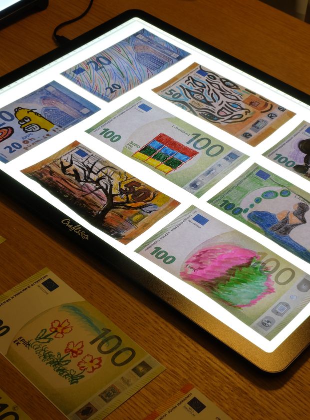 Des billets dessinés sur une table lumineuse